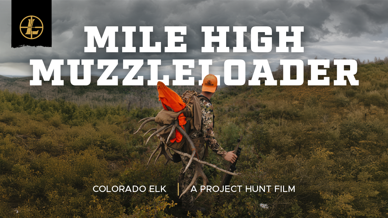 hunter packing out elk antlers on back in colorado wilderness