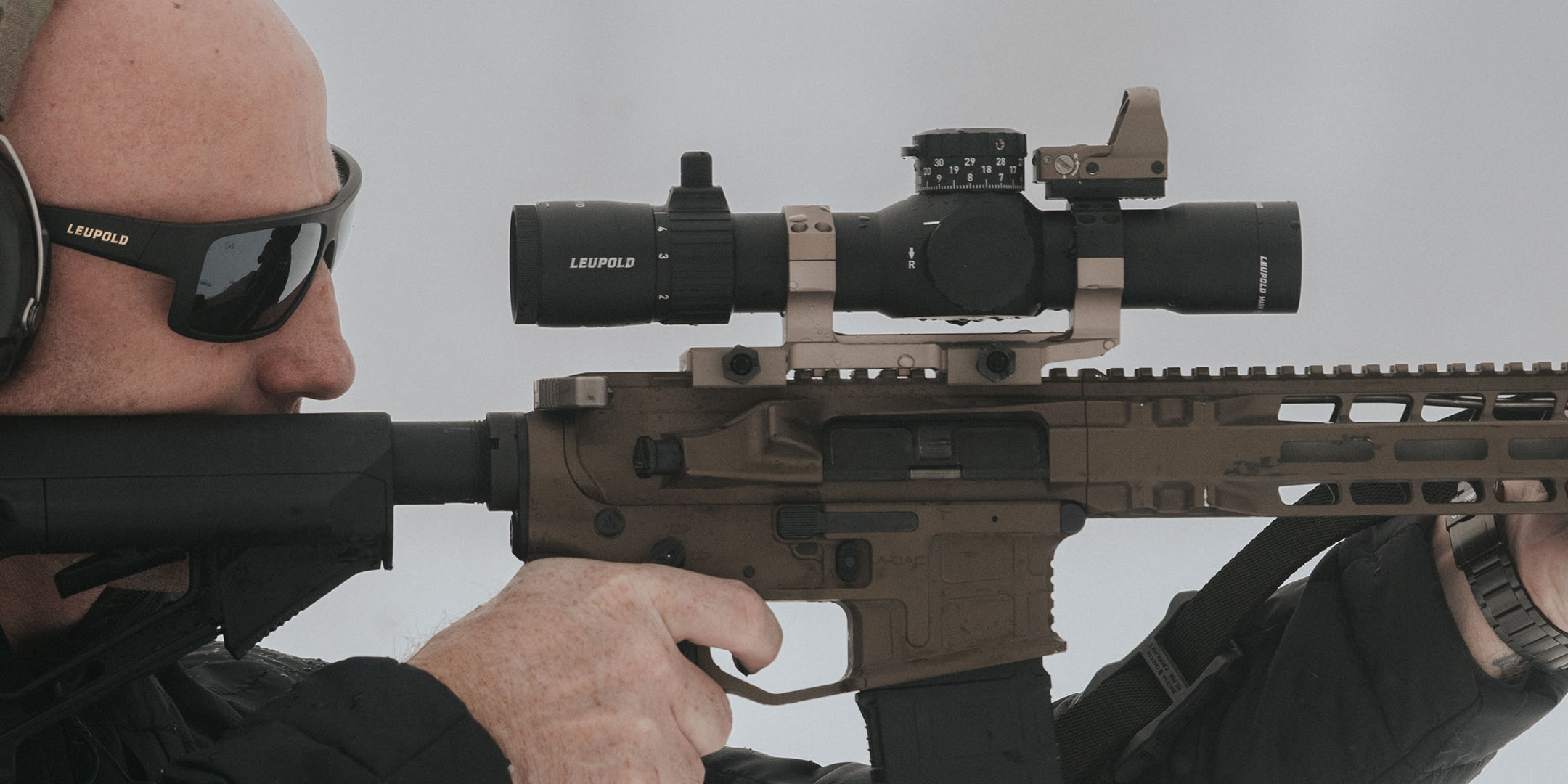 Man taking aim and looking through a Leupold Mark 5HD riflescope.