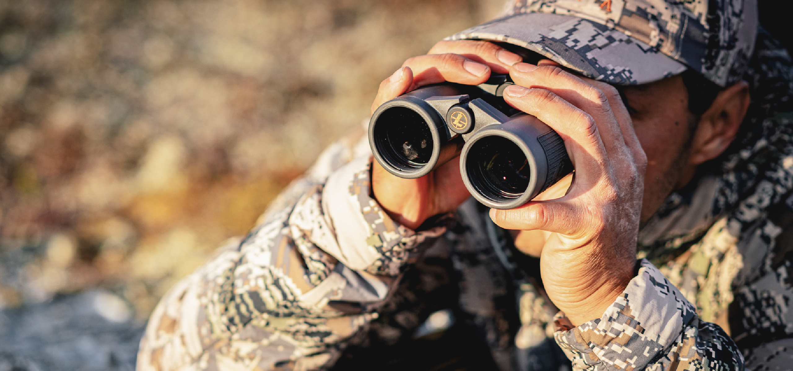 hunter wearing camouflage using leupold binoculars