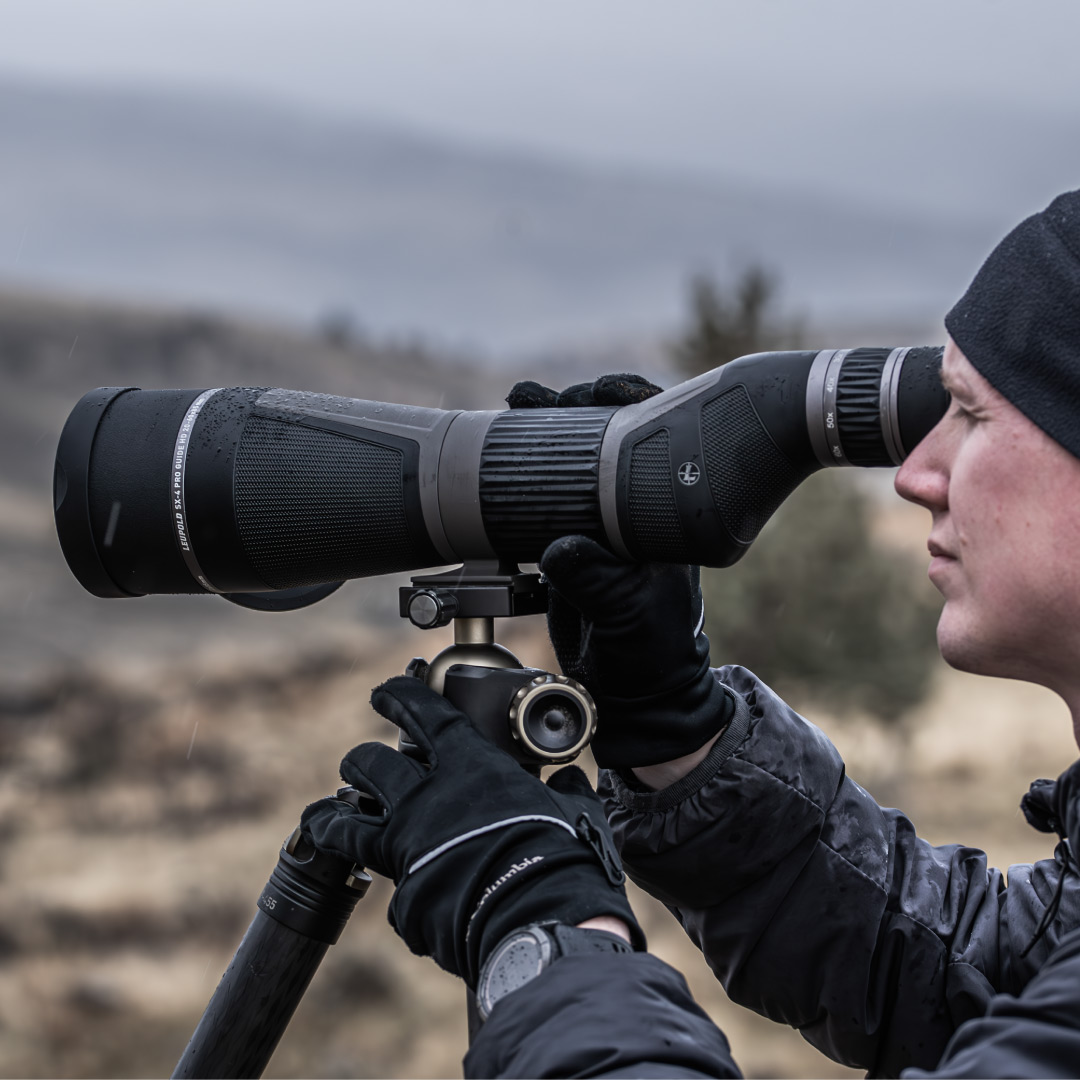 man on hill looking through leupold sx-4 pro guide hd gen 2 spotting scope on tripod