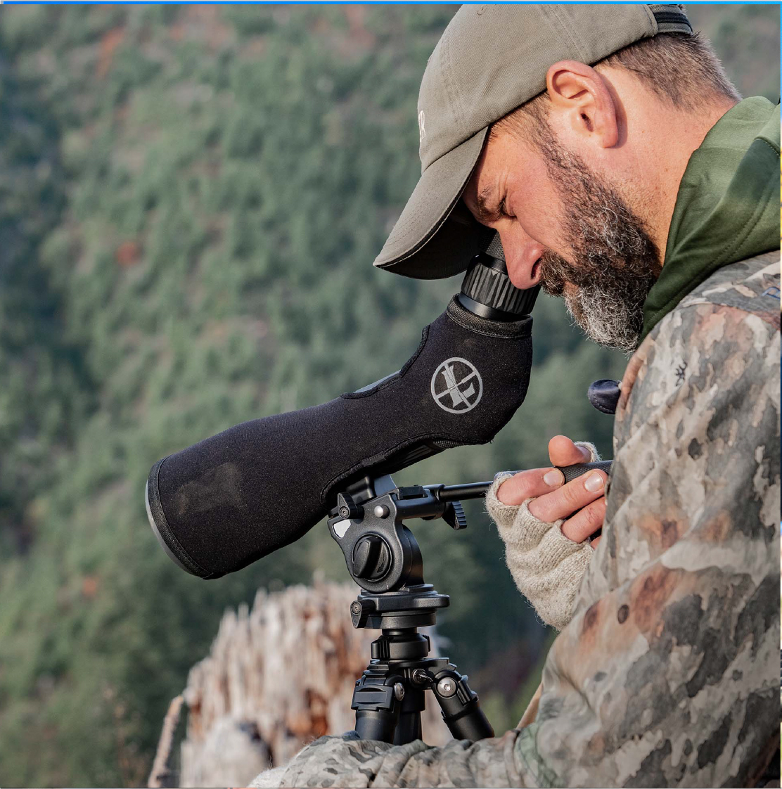 hunter wearing camouflage and hat glassing with leupold binoculars