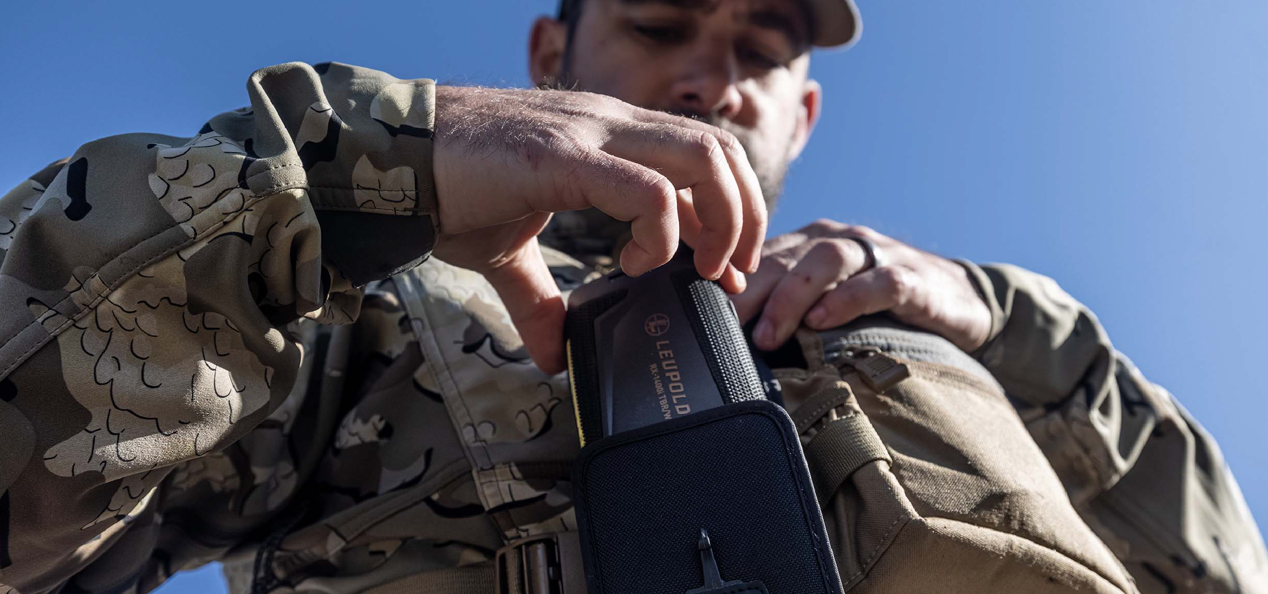 Person taking aim with a semi-automatic rifle with a Freedom Red Dot Sight mounted on top.