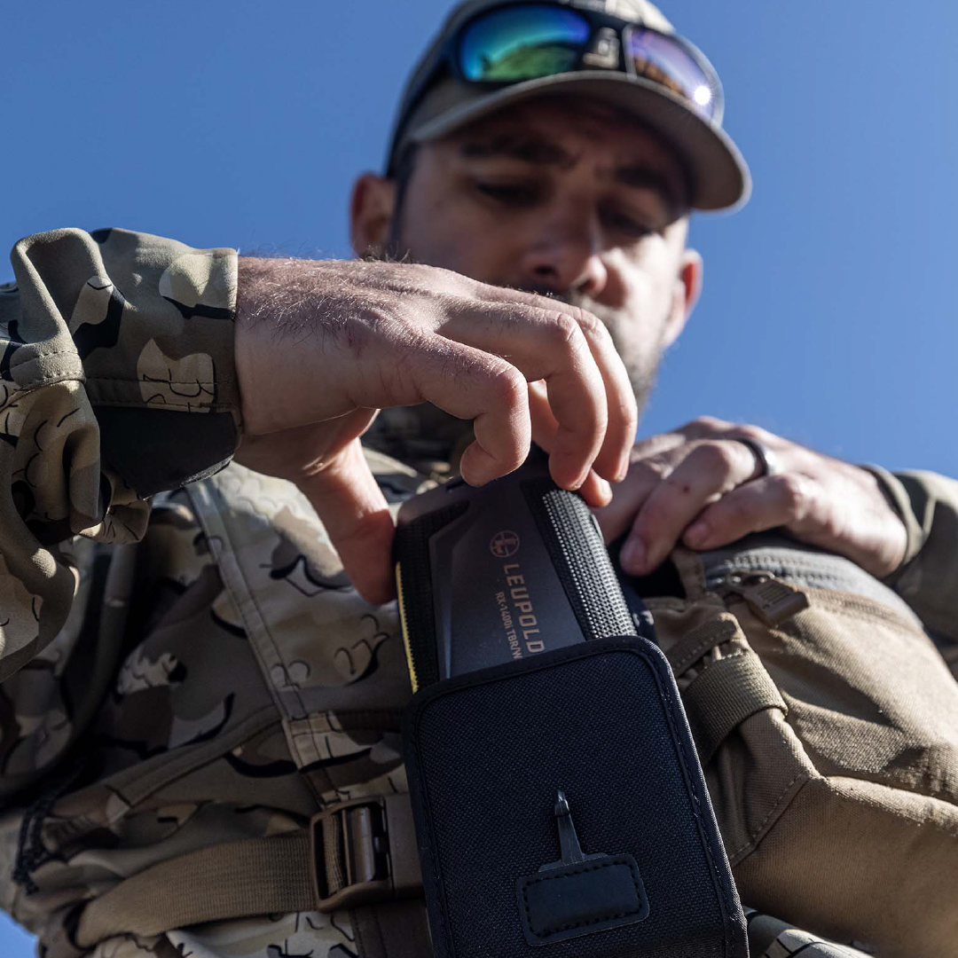 Person taking aim with a semi-automatic rifle with a Freedom Red Dot Sight mounted on top.