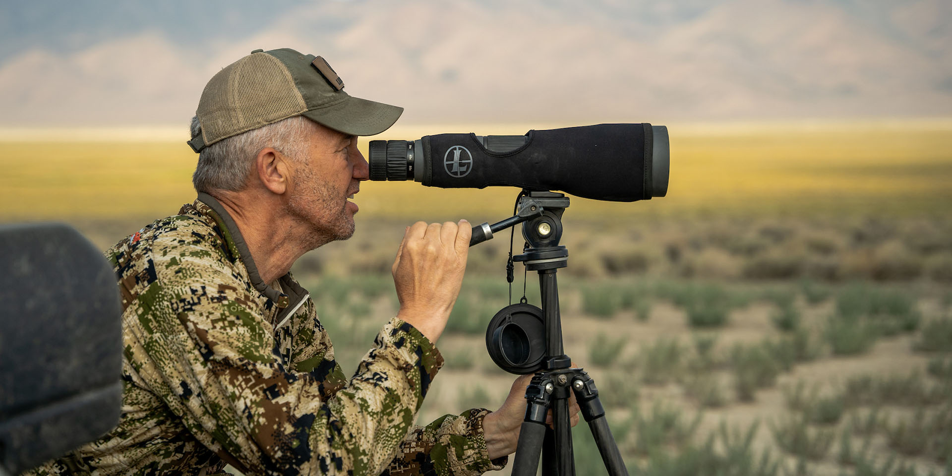 Randy Newberg glassing in open range with a Leupold spotting scope.