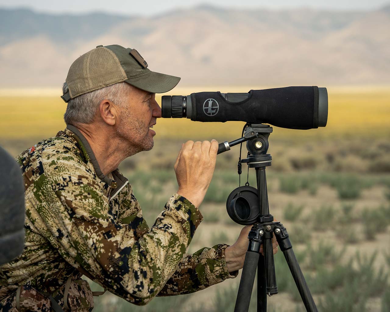 Randy Newberg glassing in open range with a Leupold spotting scope.